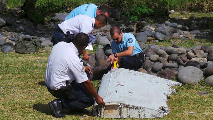Policisté s nalezeným kusem letadla.