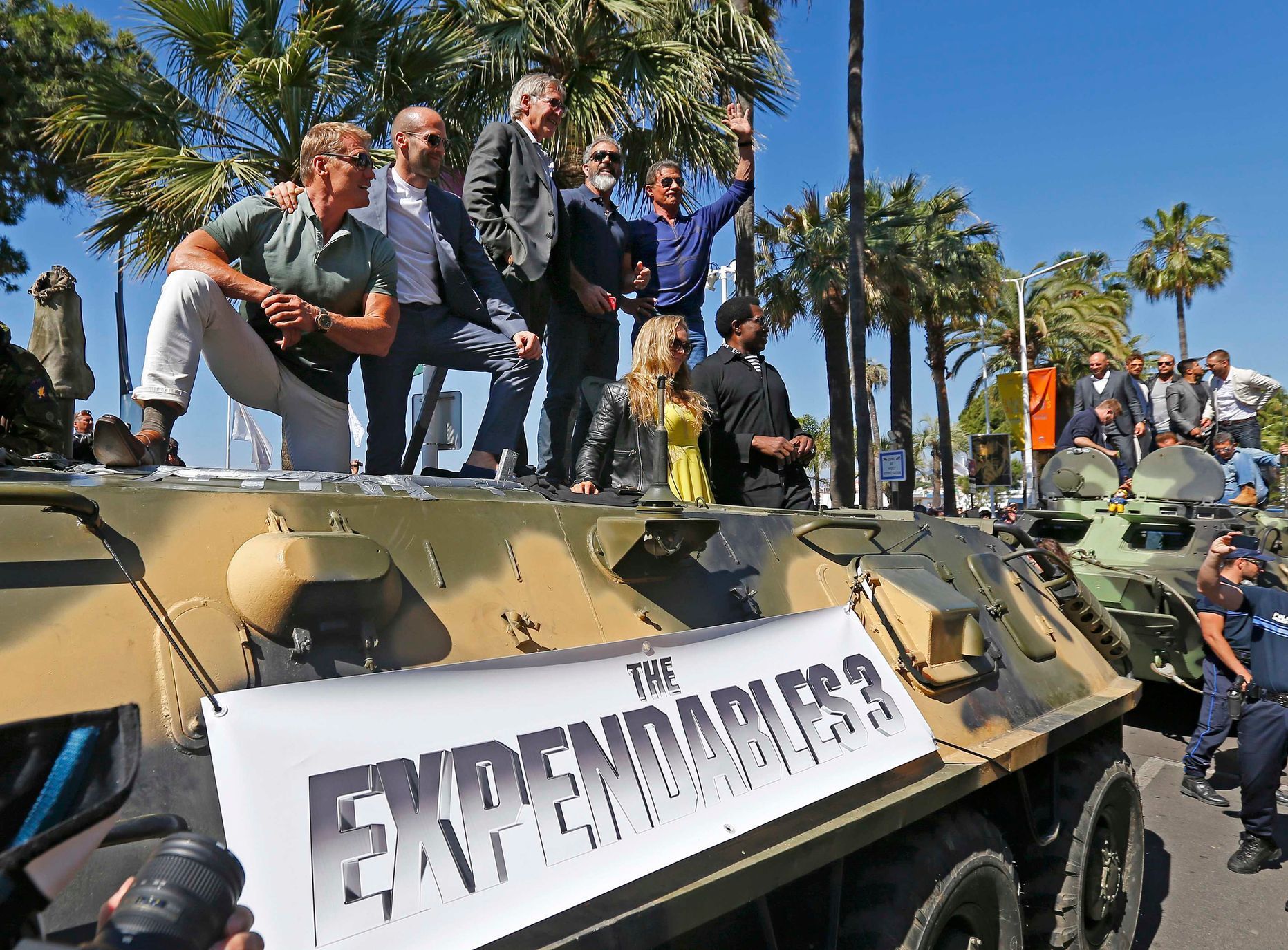Cast members Dolph Lundgren, Jason Statham, Harrison Ford, Mel Gibson, Ronda Rousey, Sylvester Stallone, Wesley Snipes pose on a tank as they arrive on the Croisette to promote the film &quot;The Expe