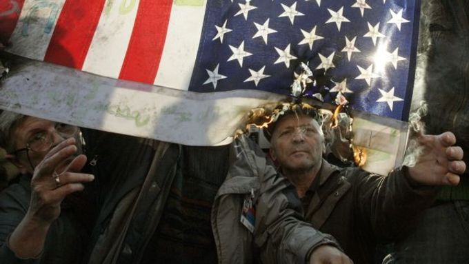 Demonstranti zapalují v Bělehradě americkou vlajku.