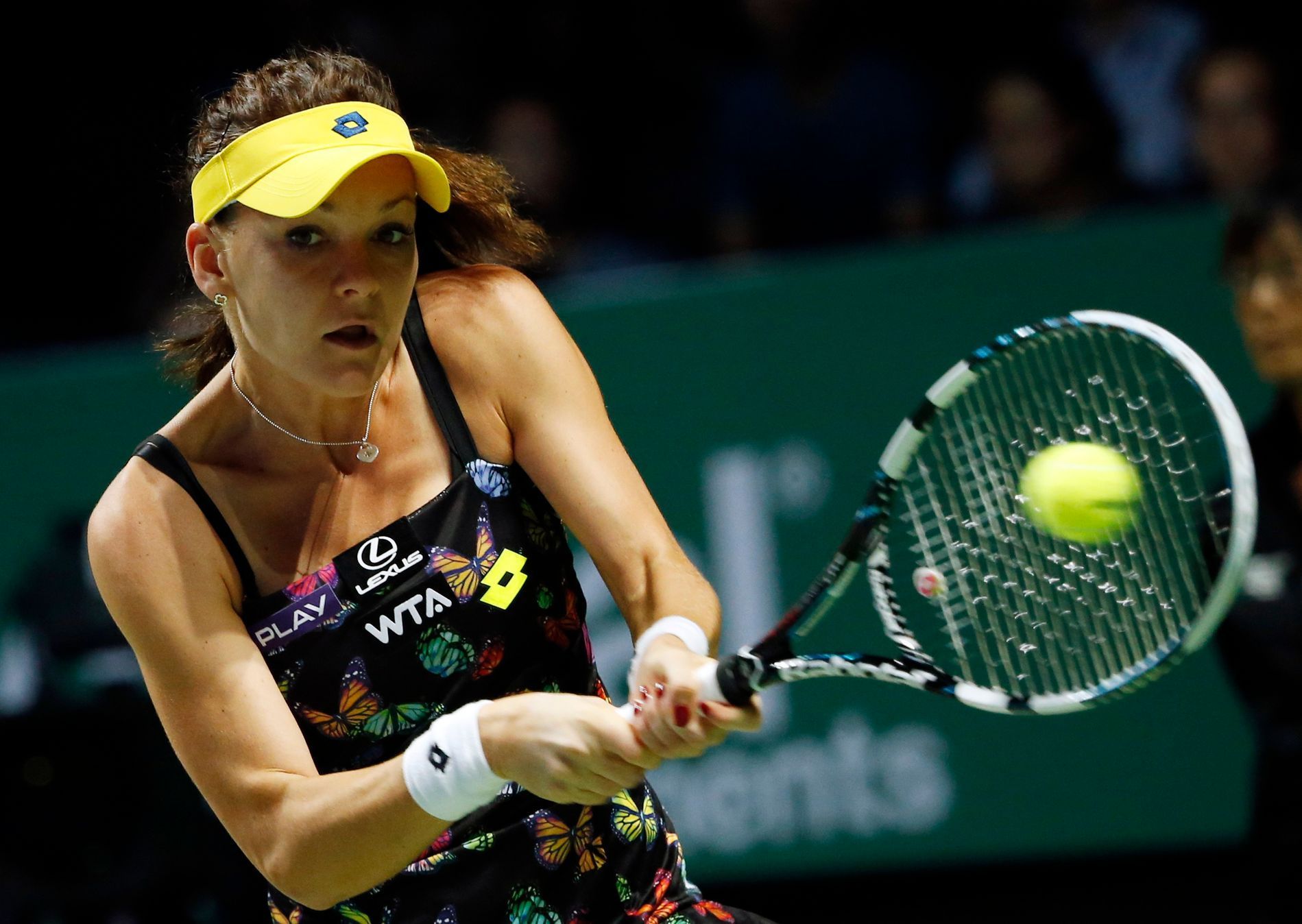 Radwanska of Poland hits a return to Wozniacki of Denmark during their WTA Finals singles tennis match at the Singapore Indoor Stadium