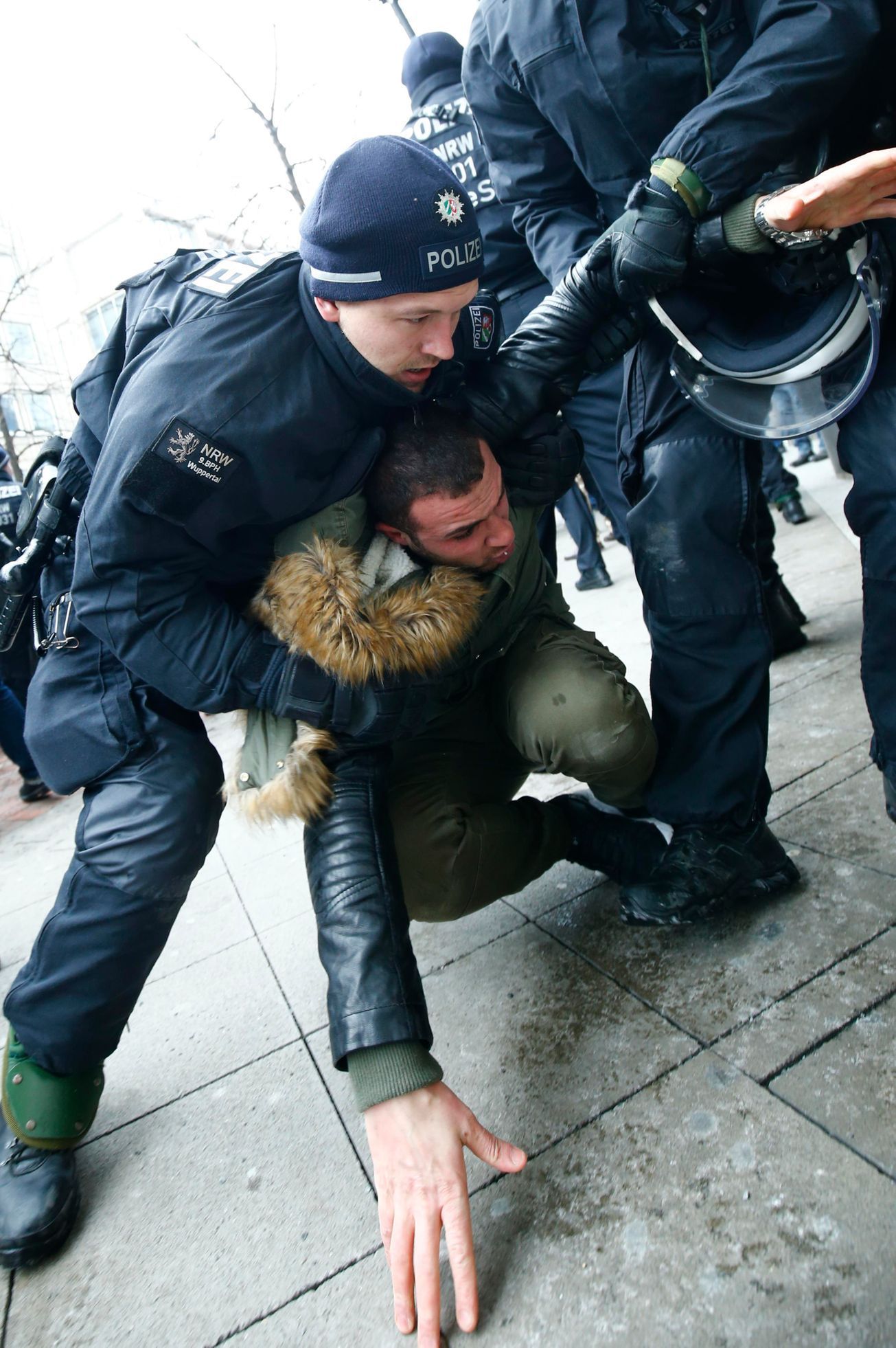 Německý policista zasahuje proti kurdskému demonstrantovi v Hannoveru.