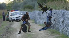 Uprchlíci překonávají na maďarské hranici ostnatý drát