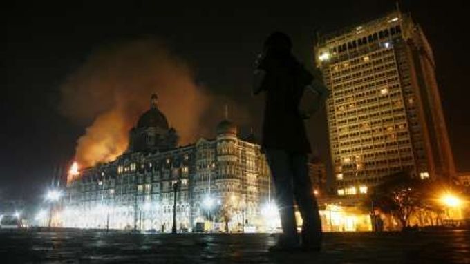 Reportér sleduje hustý dým, který stoupá z obklíčeného hotelu Taj Mahal, který vzali ozbrojenci útokem