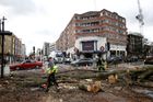 Workers remove a tree lying across a road after it was blown over by high winds, in London