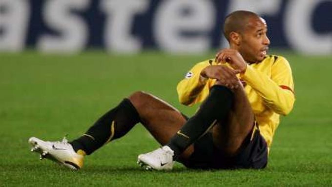 Útočník Arsenalu Londýn Thierry Henry sedí na trávníku během utkání s Juventusem.