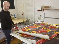 Oldřich Sova ukazuje vytištěný vzor českých biatlonových kombinéz, který stroj nažehlí na textil.
