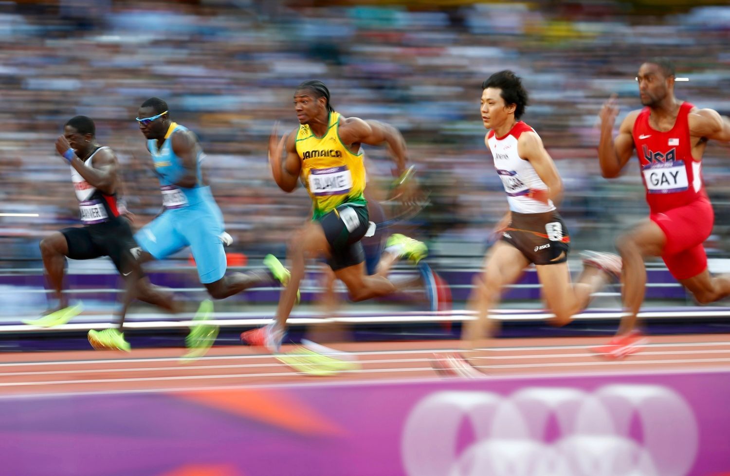 Jamajský sprinter Yohan Blake (uprostřed) běží v semifinále na 100 metrů během OH 2012 v Londýně.