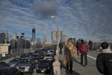 Po sérii neklidných dnů, kdy oblohu na New Yorkem zakrývala hustá oblaka, tady konečně prosvitlo modré nebe. Dívate se na lidi přecházející slavný Brooklyn Bridge.