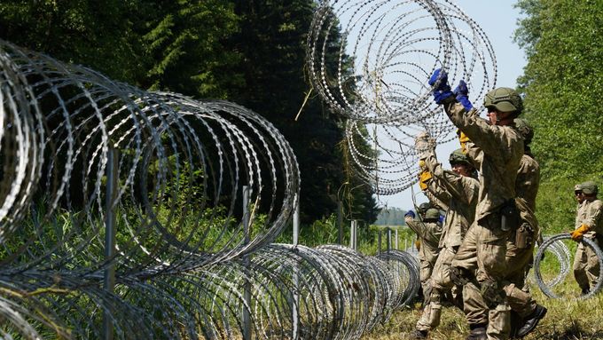 Ilustrační foto. Vojáci staví ostnatý drát na hranicích s Běloruskem, aby zabránili příchodu migrantů.