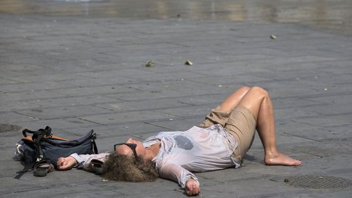 Žena odpočívá u fontány v centru Bruselu.