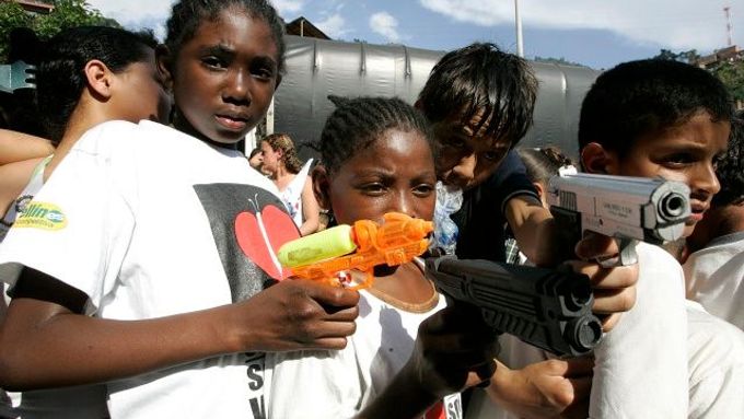 Bezpečnost měst je palčivým problémem v celé zemi. Na fotogfarii demonstrují za bezpečí na předměstích Medellínu místní děti - s atrapami zbraní v ruce.