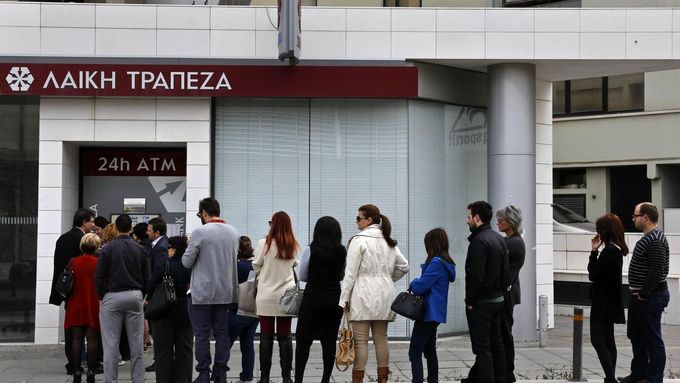 Lidé stojí frontu u bankomatu, který se nachází vedle zavřené pobočky kyperské banky Laiki Bank v Nikósii.