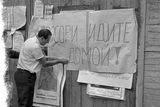 Dobový snímek vyvěšování agitačního plakátu (Agresoři jděte domů!), který byl pořízen během srpnové okupace v roce 1968.