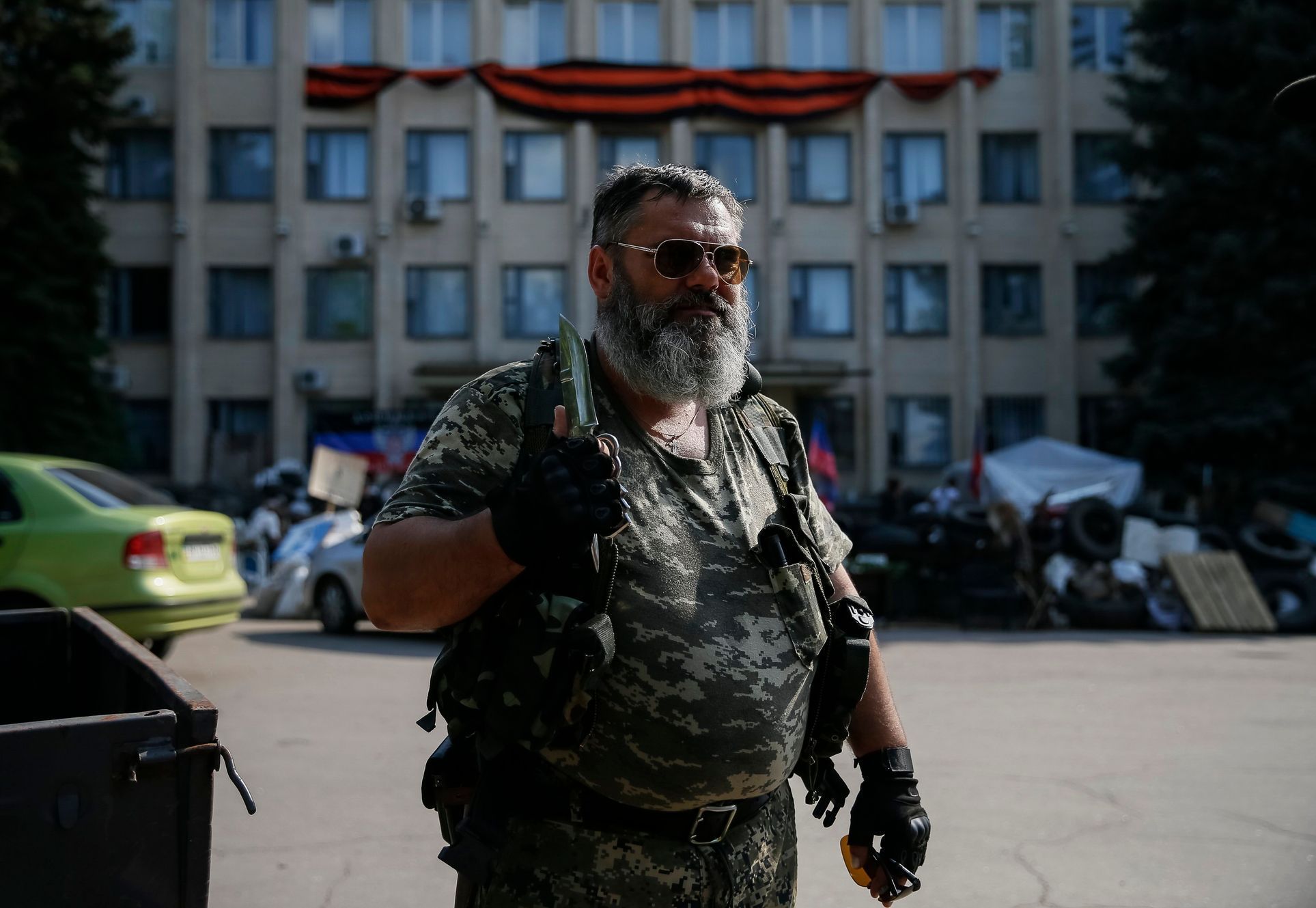 A pro-Russian rebel holds a knife as he stands near a local government building in downtown Kramatorsk