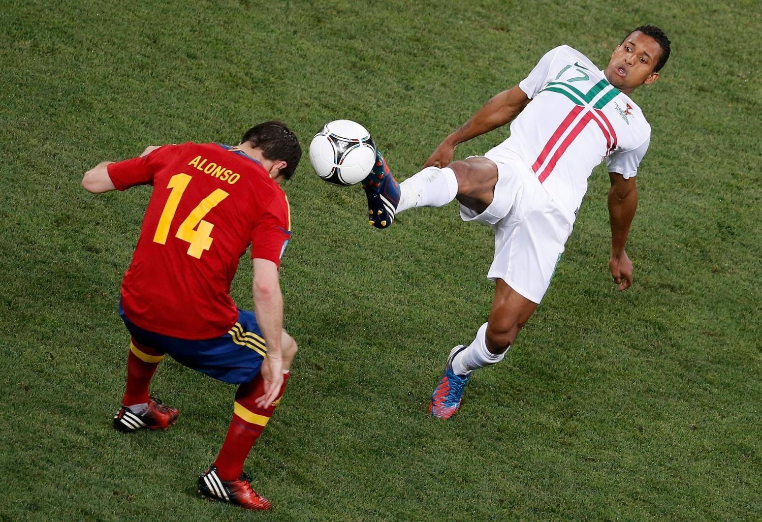 Xabi Alonso jde hlavičkou proti kopačce Naniho během semifinálového utkání mezi Portugalskem a Španělskem na Euru 2012.