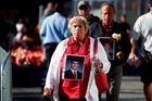 Truchlící přicházejí na Ground Zero před vzpomínkovým ceremoniálem  s fotografiemi těch, kdo zahynuli v troskách Světového obchodního centra.