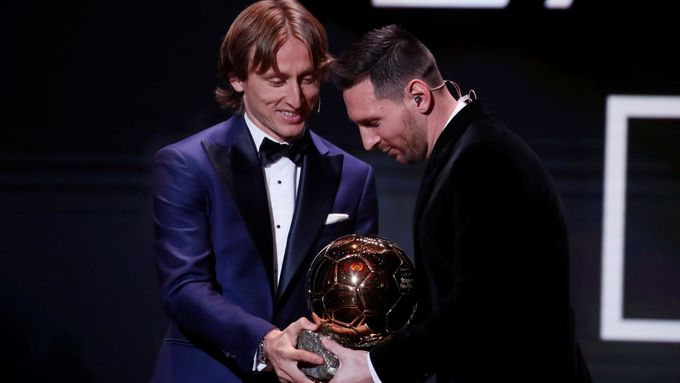 Luka Modrič předává Zlatý míč do rukou Lionela Messiho.