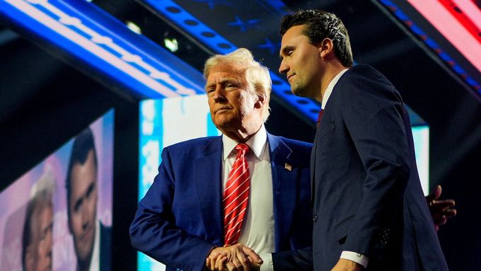 Prezident USA Donald Trump si podává ruku s Charlie Kirkem na akci AmericaFest pořádané Turning Point USA. Archivní foto.