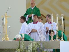 Papež uctívá oltář na poli v Tuřanech políbením.