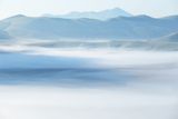 Brzy ráno se nad náhorní planinou u italské vesnice Castelluccio di Norcia válí mlhy.