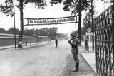 Voják střeží vstup do olympijské vesnice, ozdobený výmluvným nápisem: Německá branná moc zdraví své hosty!