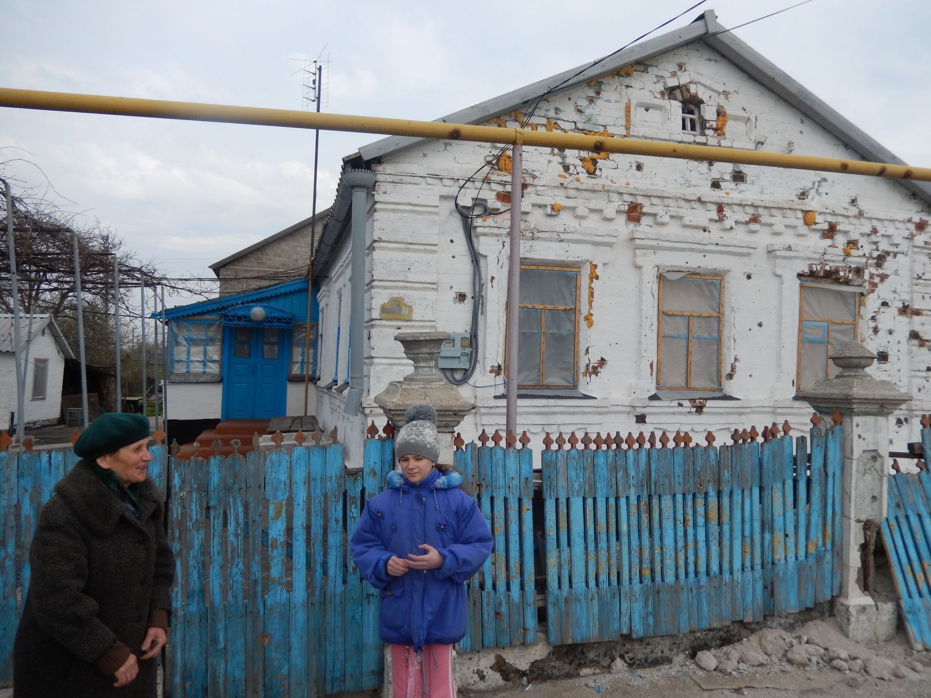 Nina Alexejevna s vnučkou před svým domkem ve vesnici Sartana východně od Mariupolu.