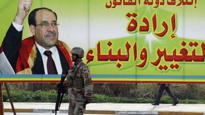 Voják před plakátem propagujícím před volbami premiéra Nurího Malikího a jeho blok Právní stát