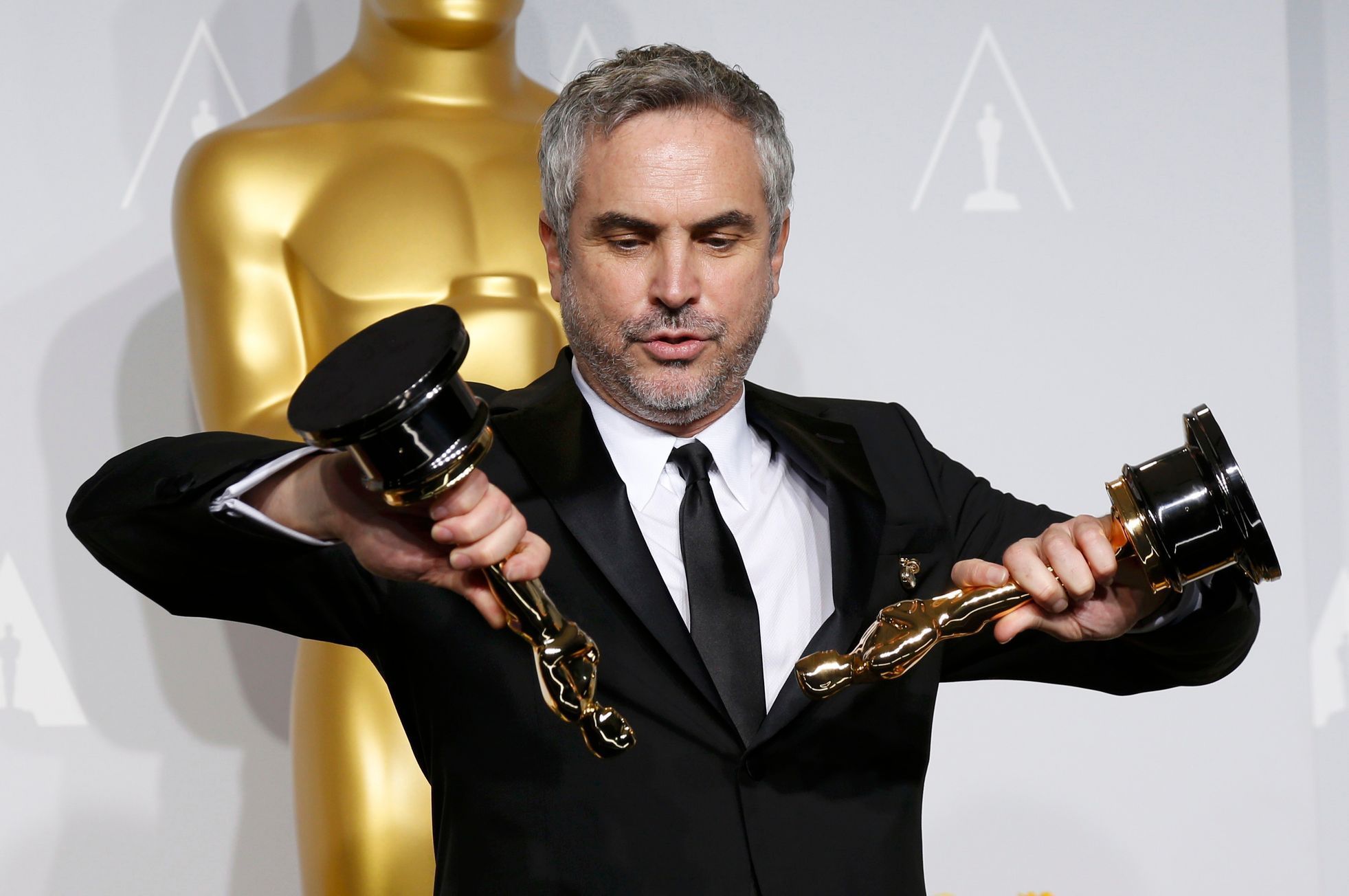 Alfonso Cuaron poses with the awards for best director and best film editing for &quot;Gravity&quot; at the 86th Academy Awards in Hollywood