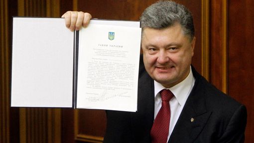 Ukrajinský prezident Petro Porošenko ukazuje podepsanou asociační dohodu s Evropskou unií. Tu v úterý 16. září ratifikovaly parlament i europarlament.