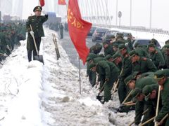 Čínští vojáci odklízejí sníh.