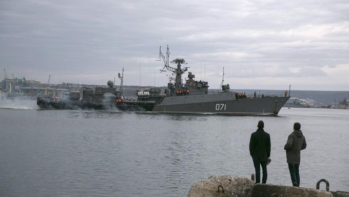 Lidé sledují ruskou námořní loď vplouvající do přístavu ve městě Sevastopol, 2. března 2014.