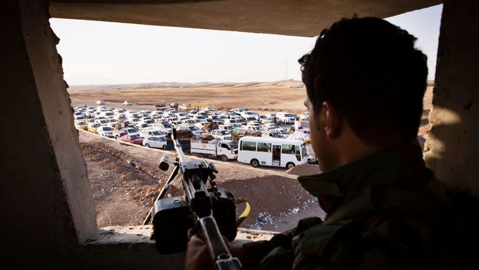 Irácký voják sleduje konvoj uprchlíků z Mosulu..