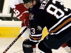 Aleš Hemský z Edmontonu (v tmavém) bojuje o puk s detroitským útočníkem Stevem Yzermanem.