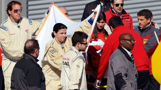 Zdravotníci transportují otřeseného Fernanda Alonsa do vrtulníku , který pak z okruhu v Barceloně zamířil na nedalekou kliniku.