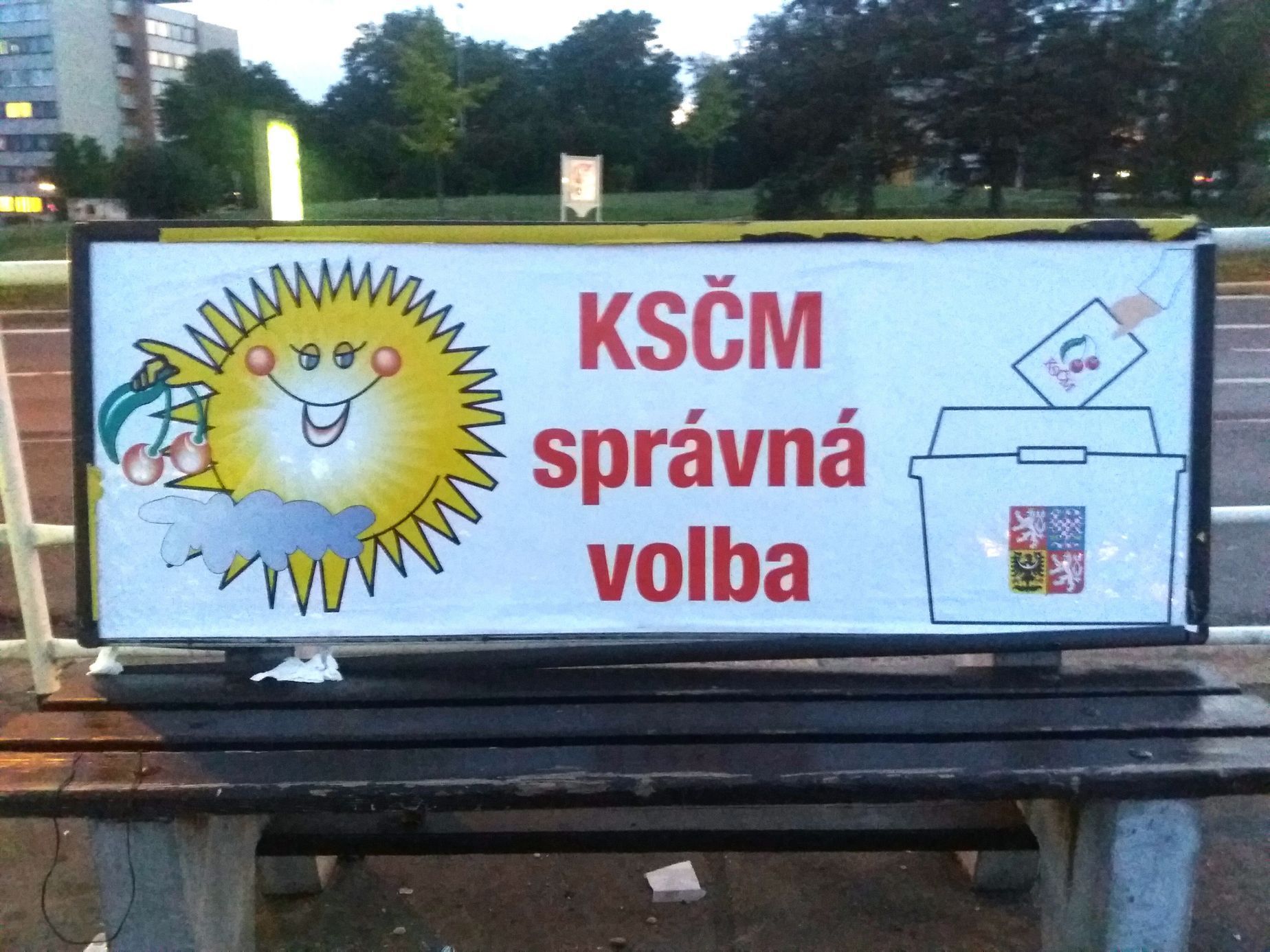 Plakát KSČM na lavičkách se sluníčkem