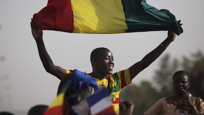 A Malian man waves a Mali flag as France's President Francois Hollande (not pictured) speaks at Independence Plaza in Bamako, Mali February 2, 2013. France will withdraw its troops from Mali once the Sahel state has restored sovereignty over its national territory and a U.N.-backed African military force can take over from the French soldiers, Hollande said on Saturday. REUTERS/Joe Penney (MALI - Tags: POLITICS CONFLICT) Published: Úno. 2, 2013, 8:07 odp.