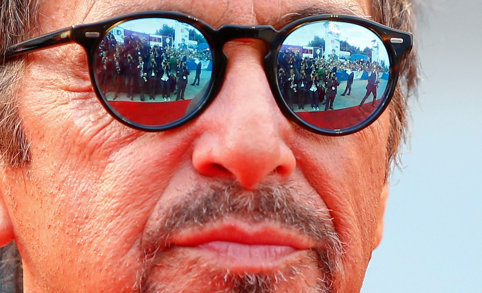 Members of the media are reflected in the sunglasses of cast member Al Pacino as he attends the red carpet for the movie &quot;Manglehorn&quot; at the Venice Film Festival