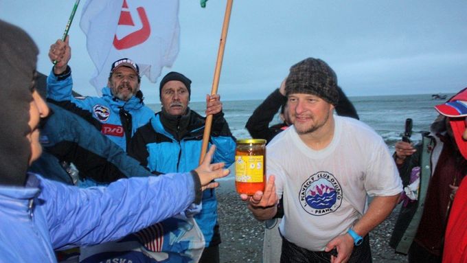 Účastník otužilecké štafety Zdeněk Tlamicha předává po dosažení Aljašky místním obyvatelům dar, český med.