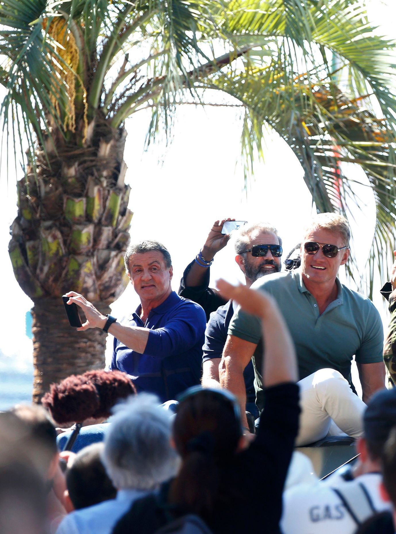 Cast members Sylvester Stallone,  Mel Gibson and Dolph Lundgren pose on a tank as they arrive on the Croisette to promote the film &quot;The Expendables 3&quot; during the 67th Cannes Film Festival in