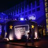 A woman walks past a banner promoting the European elections in front of the European Parliament in Brussels