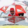 Ferrari Formula One driver Fernando Alonso of Spain sits under an umbrella during the drivers' parade ahead of the Japanese F1 Grand Prix at the Suzuka Circuit