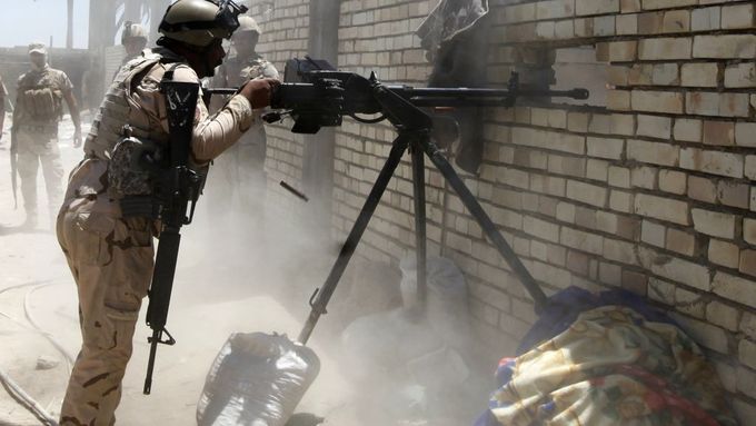Příslušník iráckých speciálních sil pálí na pozice ISIL západně od Bagdádu.