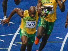 Usain Bolt předává finišmenovi Powellovi