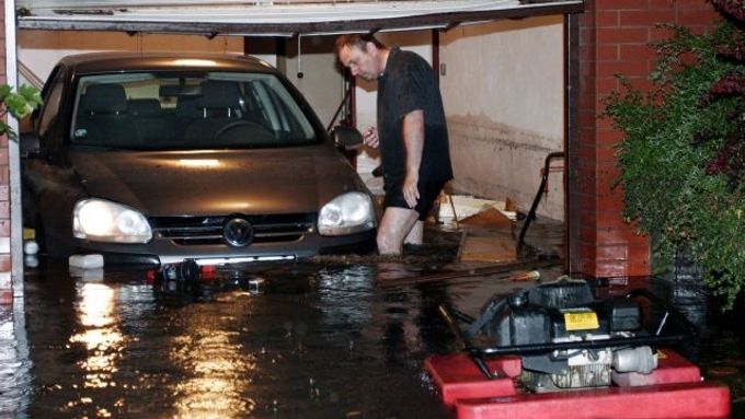 Majitel prohlíží v garáži škody, které v noci na 22. června napáchaly v Pardubicích přívalové deště a bouřky.