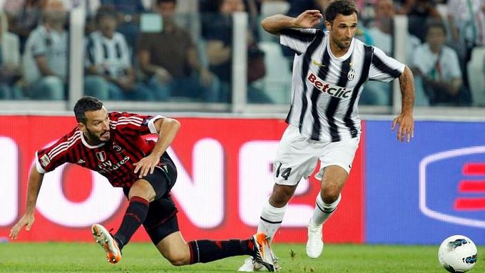 Juventuský Mirko Vučinič (vpravo) v souboji s Gianlukou Zambrottou z AC Milán