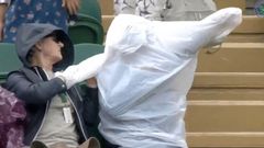 Fanoušci Wimbledonu si utahují z opilého diváka, který si nemohl navléct pláštěnku