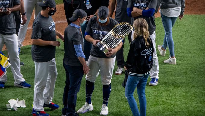 Nakažený Justin Turner slaví s trofejí pro vítěze MLB