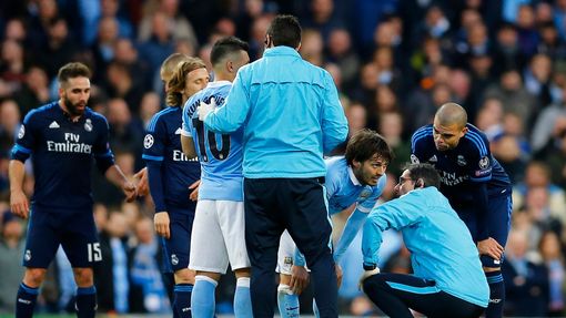 Manchester City's David Silva receives treatment after sustaining an injury as Real Madrid's Pepe looks on