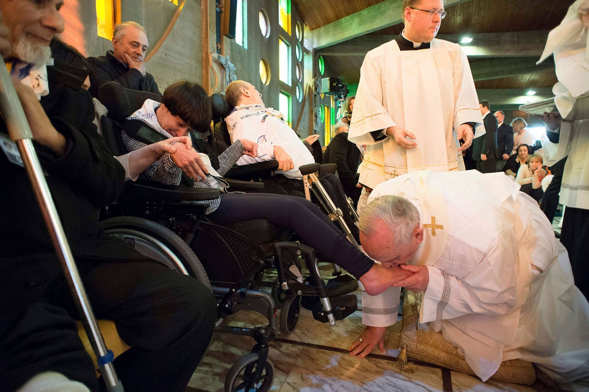 Pope Francis kisses the foot of a disabled person at the S. Maria della Provvidenza church in Rome, during Holy Thursday celebration