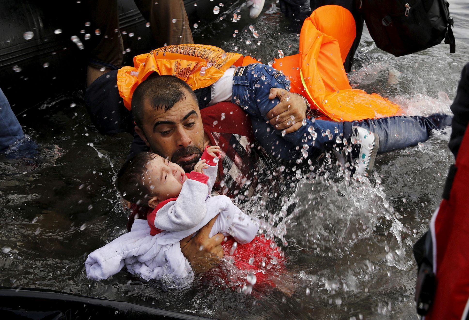 Syrský uprchlík se svými dětmi u ostrova Lesbos.